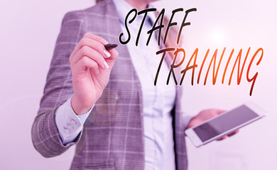 Handwriting text writing Staff Training. Conceptual photo program that helps employees learn specific knowledge Business woman pointing in empty space with pen and mobile phone