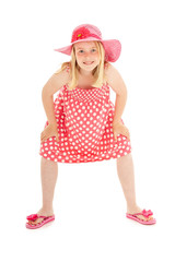 Full length shot of beautiful young blonde girl in big pink floppy hat, a polka dot dress and flip flops. Isolated on white studio background