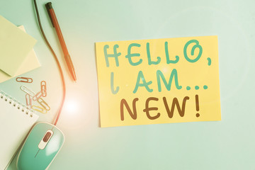 Word writing text Hello I Am New. Business photo showcasing introducing oneself in a group as fresh worker or student Cardboard and writing equipment with modern gadget above pastel backdrop
