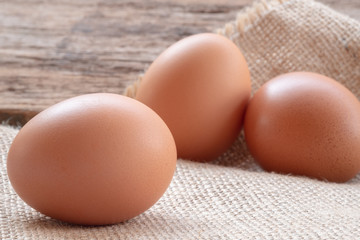 Close up raw chicken eggs with wooden background