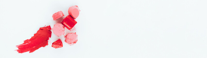 Decorative cosmetics, makeup. Smeared pink, red lipstick samples on white background.