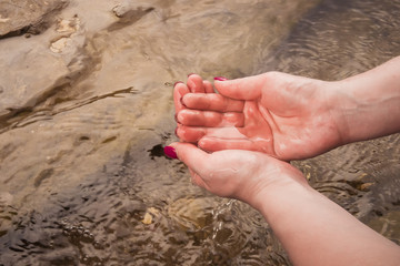 Hands in the river. Hands gaining water in a mountain river