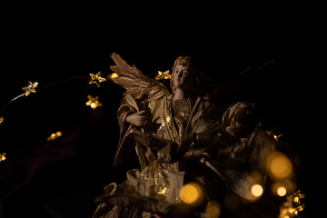A golden Ambassador fro Christmas, the smoke gold angel isolated captiured  with christmas lights 