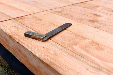Handy carpenter installing wooden planks during flooring works outside the new house. Czech republic, Europe.