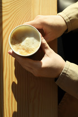 Woman with cup of fresh aromatic coffee at table in cafe