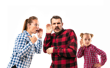 Family members arguing with one another on white studio background. Concept of human emotions, expression, conflict of generations. Woman, man and little girl. Looking for new secrets. Talk louder.