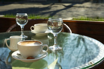 Cup of fresh aromatic coffee at table in cafe