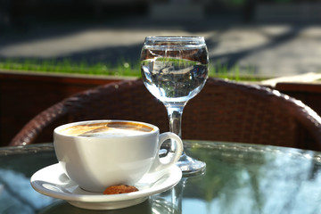 Cup of fresh aromatic coffee at table in cafe