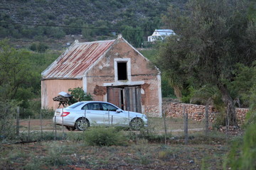 Teures Auto vor altem Haus