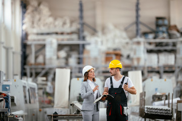 Architect and worker working on project. Colleagues discussing work in factory.