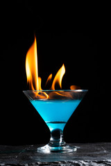 blue alcoholic beverage and fire
