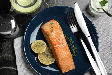 Flat lay composition with cooked red fish on dark marble table