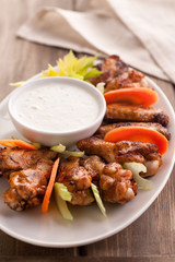 Hot buffalo chicken wings with blue cheese sauce and fresh vegetables.