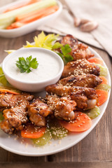 Hot buffalo chicken wings with blue cheese sauce and fresh vegetables.