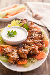 Hot buffalo chicken wings with blue cheese sauce and fresh vegetables.
