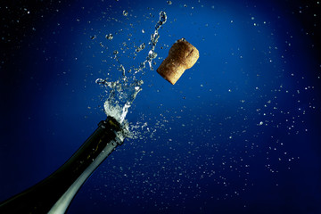 A splash of champagne from a bottle with a cork.