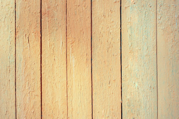 Wooden brown and yellow background of vertically arranged narrow boards. Background with bright, peeling paint. The surface of the table top view