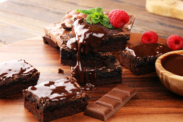 chocolate brownie cake dessert with raspberries and spices on a wooden background.