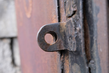 A close up shot of an old rusted key on a metal door keyhole.