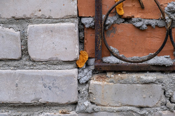 one old window behind an iron grate on a brick wall in red and grey