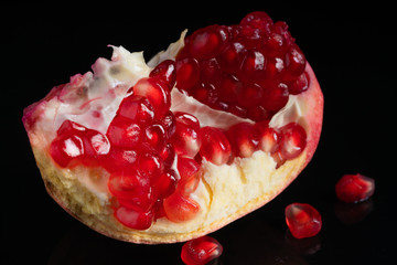 ripe and delicious pomegranate on black