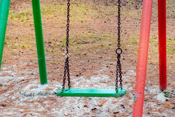 Old chain swing outdoor in Park in pine forest. Wooden seat swing seat close up