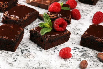 chocolate brownie cake dessert with raspberries and spices on a wooden background.