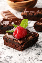 chocolate brownie cake dessert with raspberries and spices on a wooden background.