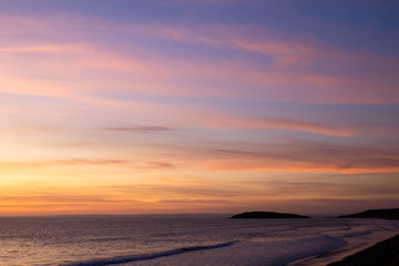 Beach with pink sunset and headland  