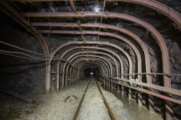Fototapeta na wymiar Gold iron mine ore shaft tunnel drift with rails underground