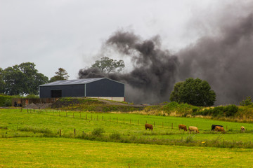 Thick black smoke from burning rubber tyres on a farm