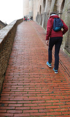 young boy walks on the pathway of the Ducal Palace in Urbino Tow