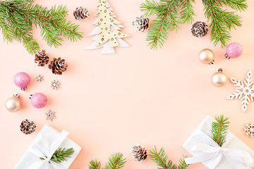 Flat lay frame with spruce branche, christmas decorations and gift box on a color background