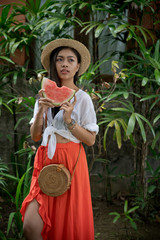 Obraz na płótnie Canvas Asian girl portrait with watermelon slice fruit. Beautiful Balinese women. Beauty salon, fresh, summer concept