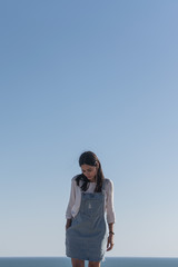 Young lady in blue dress enjoying the beach at a sunny afternoon