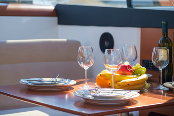 Setout table - tableware, sweet fruits, wine and glasses