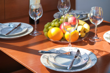 Setout table - tableware, sweet fruits, wine and glasses