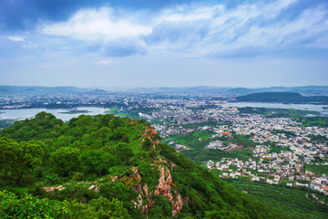 Obraz premium Top view of beautiful city of lakes, udaipur on the rainy day from sajjangarh fort, the top peak of the city build by king of rajasthan, India 