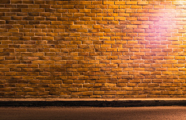 Photo of retro brown brickwall with light with copy space. Concept for backdrop, background, banner, brick pattern, construction and building structure, and wallpaper.