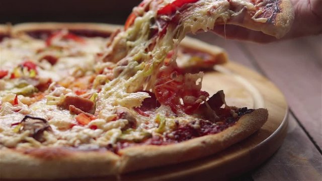 man hand take hot pizza slice with stretching cheese close up