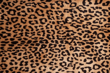 Faux fur leopard texture background. Fashionable modern ecological material. Plaid or carpet.