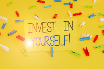 Text sign showing Invest In Yourself. Business photo text nvesting in a coach or a training to learn new things Colored clothespin papers empty reminder yellow floor background office