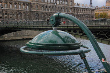 green street lamp over the waters on the bank of Seine in Paris, France