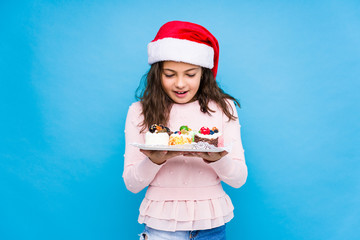 Little girl holding sweets celebrating christmas day