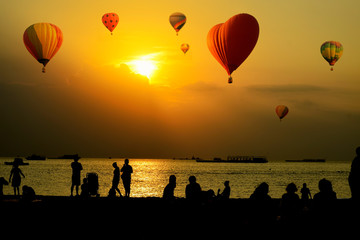 People and hot air balloon at the sunset.