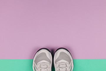 Grey sneakers on the violet and turquoise background. Concept for healthy lifestyle and everyday training.