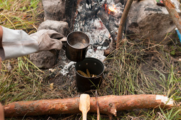 Aromatic and hot herbal tea  on campfire	