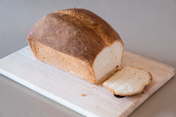 Freshly baked loaf of white bread on a wooden board