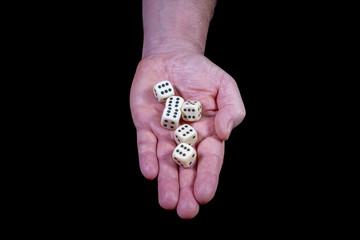 Sechs Spielwürfel liegen auf einer flachen Hand die alle die Augen sechs zeigen