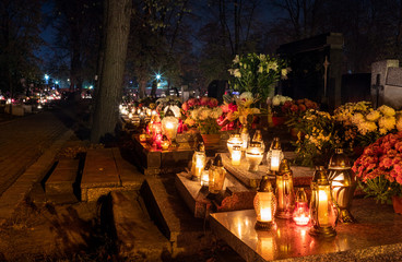 Burning candles on graves during All Saints Day